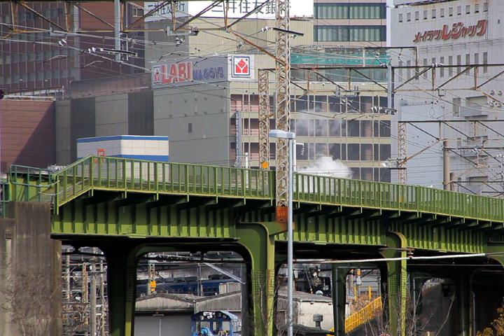 緑の橋脚の間に姿を見せる蒸気機関車