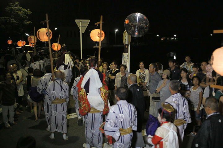 稚児を肩に乗せ飾橋に向かう